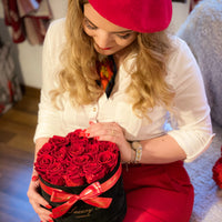 woman with valentine's day gift red infinity roses in box