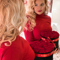 woman with red eternity roses in black velvet box