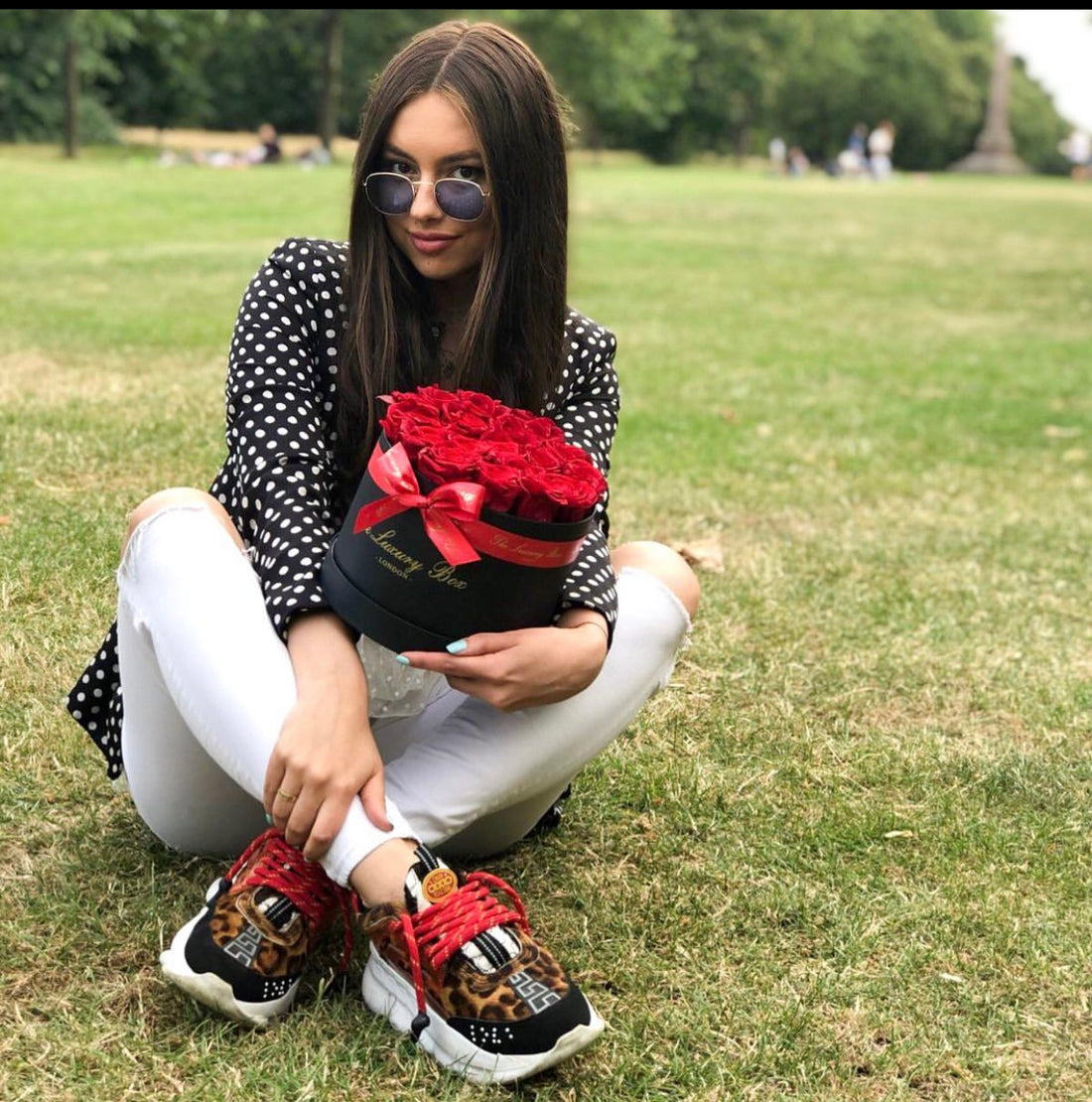woman smiling with gift for her, red eternity roses in black box