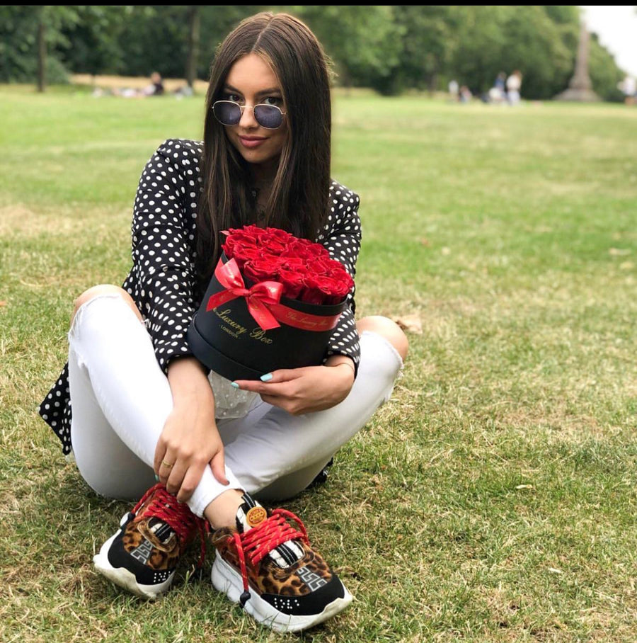 woman smiling with gift for her, red eternity roses in black box